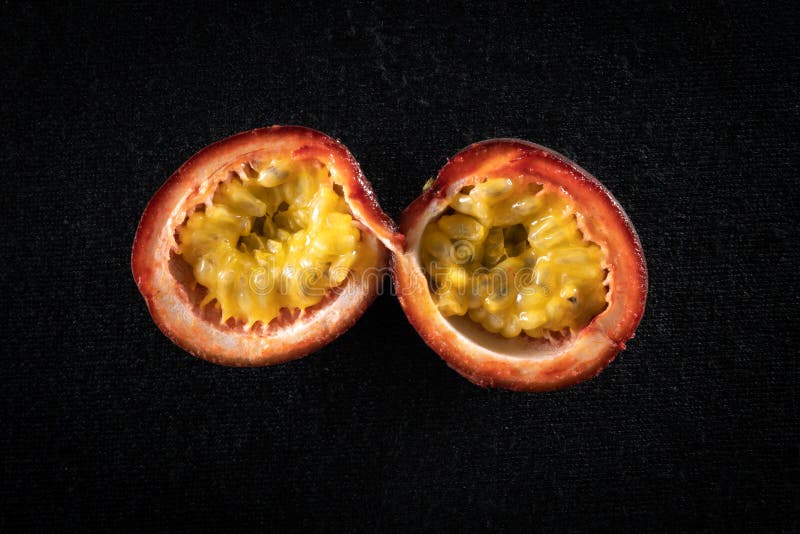 Passion Fruit Cut in Half, Arranged on a Black Background Stock Photo