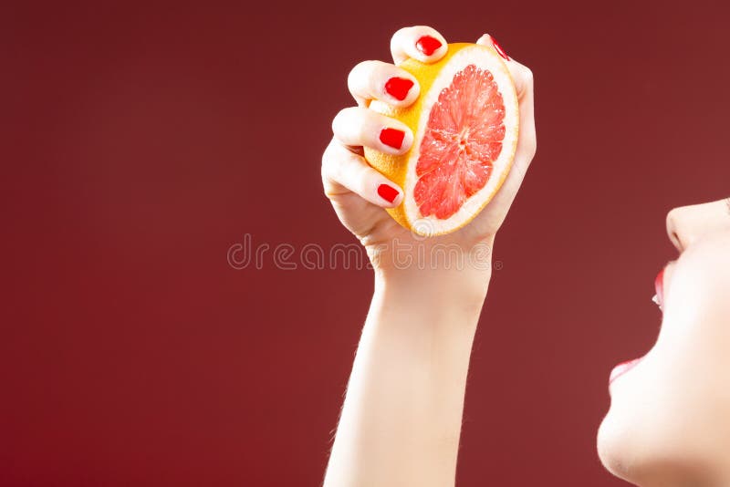 Passion Fruit Series. Closeup of Hand of Caucasian Girl Squeezing Grapefruit