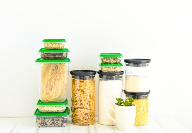 Pasta and cereals in glass and plastic jars on white background. Organized kitchen and healthy eating concept