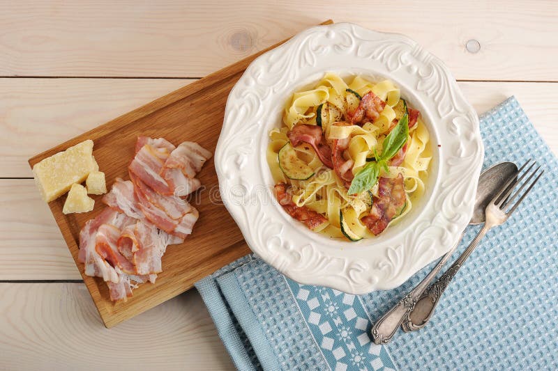 Pasta con bacon, lo zucchini ed il formaggio in una ciotola immagine stock libera da diritti Pasta con bacon, lo zucchini ed il formaggio in una ciotola immagine stock libera da diritti