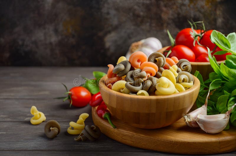 Pasta cruda con i pomodori ciliegia, il basilico, il peperoncino e l'aglio freschi per alimento italiano fotografie stock libere da diritti Pasta cruda con i pomodori ciliegia, il basilico, il peperoncino e l'aglio freschi per alimento italiano fotografie stock libere da diritti