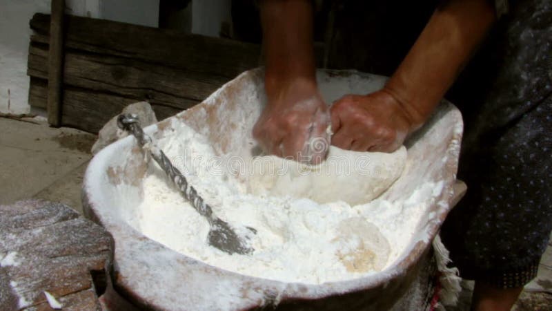 Pasta de amasamiento de la mujer mayor en un cuenco de madera almacen de video