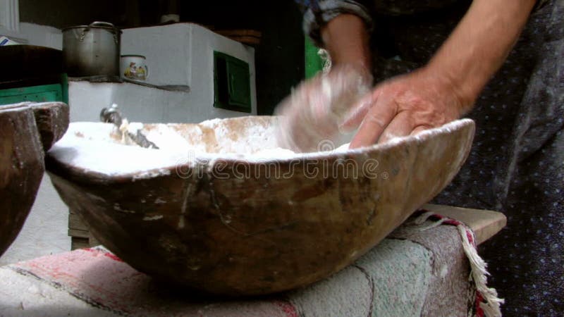 Pasta de amasamiento de la mujer mayor en un cuenco de madera almacen de video