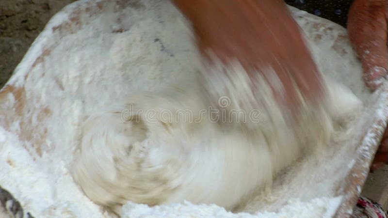 Pasta de amasamiento de la mujer mayor en un cuenco de madera almacen de video
