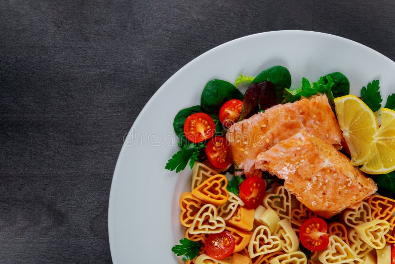 Pasta in the form of a heart salad with salmon and vegetables stock photos Pasta in the form of a heart salad with salmon and vegetables stock photos