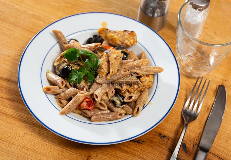 Pasta with fried chicken and vegetables stock images