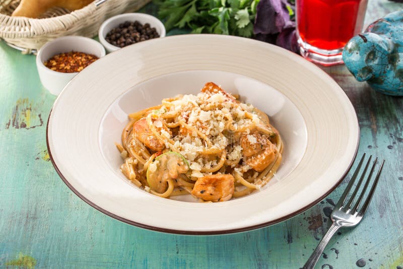 pasta italiana con zucchini, pollo e parmigiano su tavolino di legno blu immagine stock libera da diritti pasta italiana con zucchini, pollo e parmigiano su tavolino di legno blu immagine stock libera da diritti