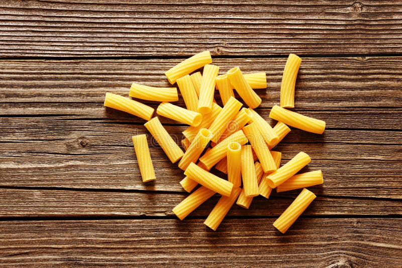 Pasta italiana gialla su un fondo rustico di legno fotografie stock libere da diritti Pasta italiana gialla su un fondo rustico di legno fotografie stock libere da diritti