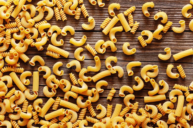 Pasta italiana gialla su un fondo rustico di legno fotografia stock libera da diritti Pasta italiana gialla su un fondo rustico di legno fotografia stock libera da diritti