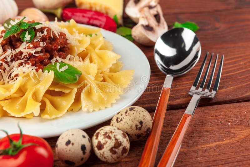 Pasta with Meat, Tomato Sauce and Vegetables on the Table Stock Photo