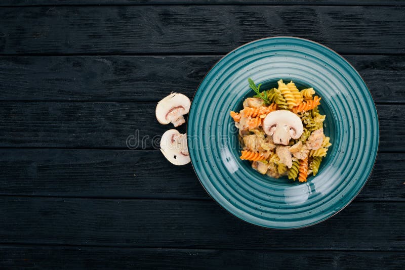Pasta with Mushrooms and Chicken. on a Wooden Background. Italian
