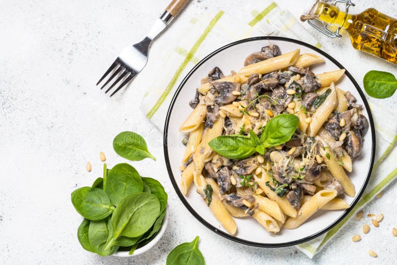 Pasta with Mushrooms and Spinach on White. Stock Photo Image of