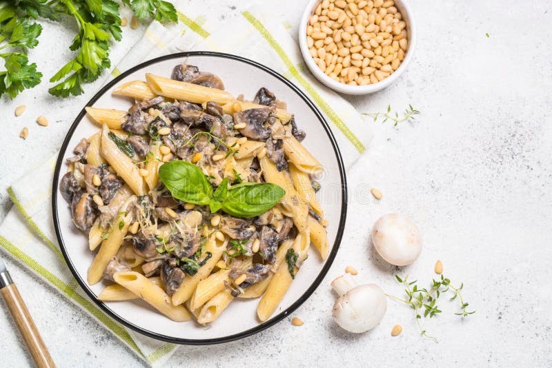 Pasta with Mushrooms and Spinach on White. Stock Photo Image of