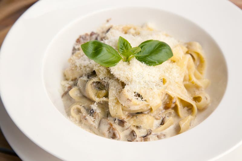Pasta with Mushrooms in White Sauce on the Plate. European Cuisine