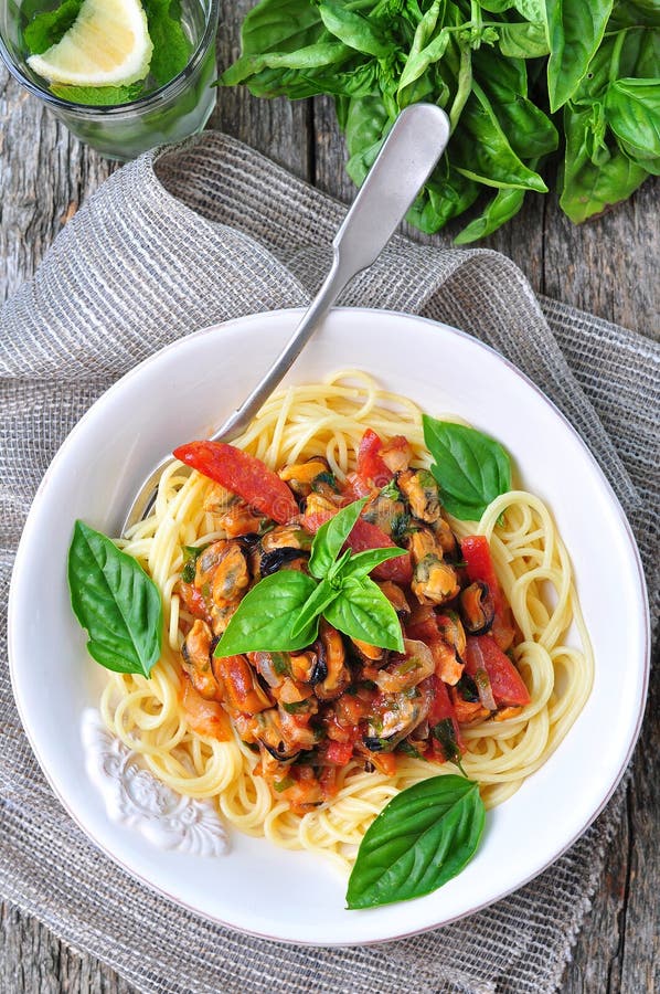 Pasta with mussels, pepperoni, bacon, tomato and basil