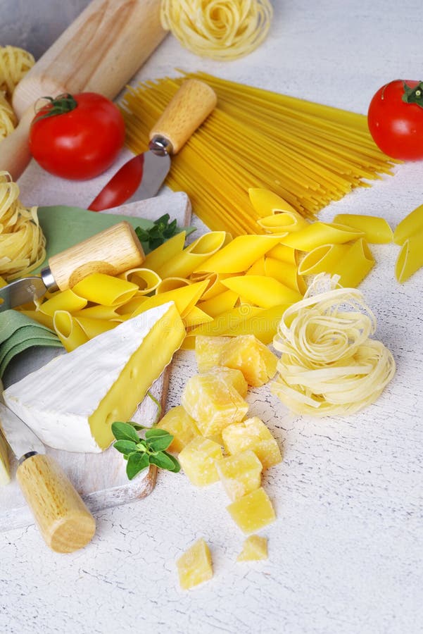 Pasta och ost med olika ingredienser för att laga mat på en ljus lantlig bakgrund fotografering för bildbyråer Pasta och ost med olika ingredienser för att laga mat på en ljus lantlig bakgrund fotografering för bildbyråer
