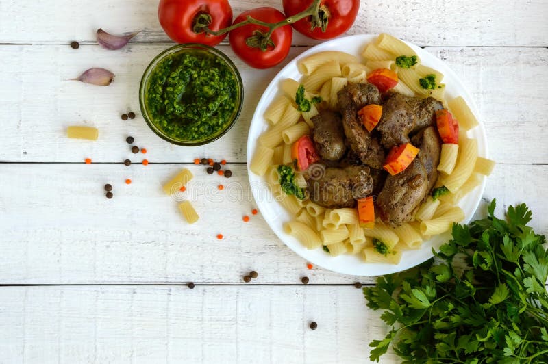 Pasta och stekt gåslever (höna, and) med pesto och tomat arkivfoto Pasta och stekt gåslever (höna, and) med pesto och tomat arkivfoto
