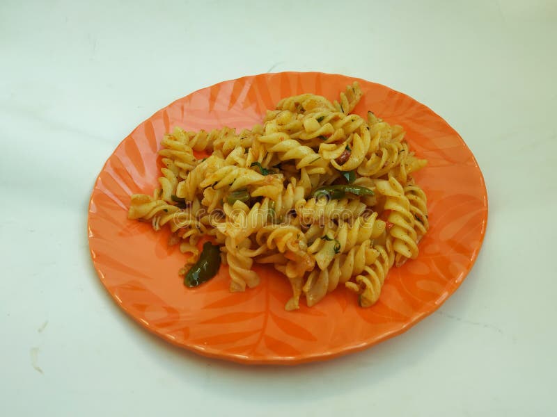 Home Made Pasta. Pasta in a Orange Color Plate isolated in a white Background. Kid Hand of Picking Pasta Food