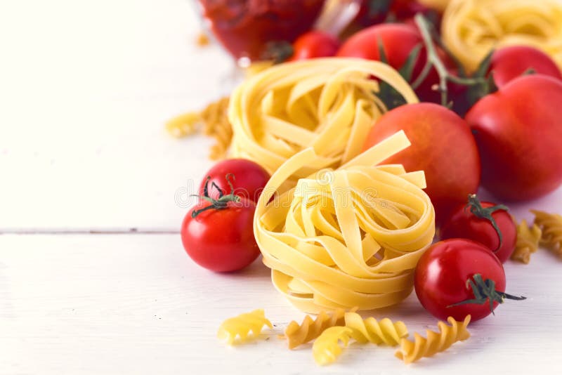 Pasta Products with Tomato Cheese Raw Pasta Fusili Fettuccine Ingredients Italian Food White Background Close Up Copy Space Toned