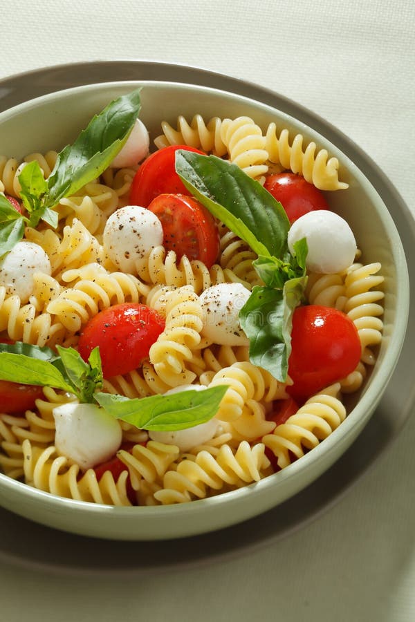 Pasta Salad with Cherry Tomatoes and Basil Leaves Stock Image - Image