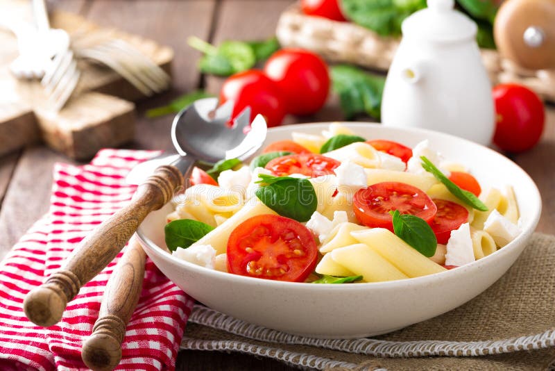 Pasta salad with fresh red cherry tomato and feta cheese. Italian cuisine