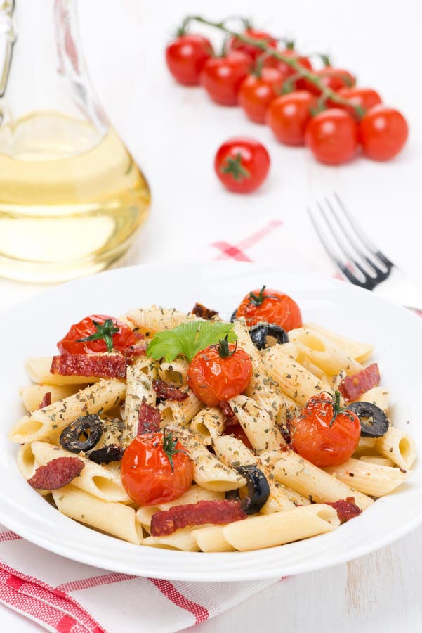 Pasta with sausage, cherry tomatoes and olives, vertical royalty free stock photos