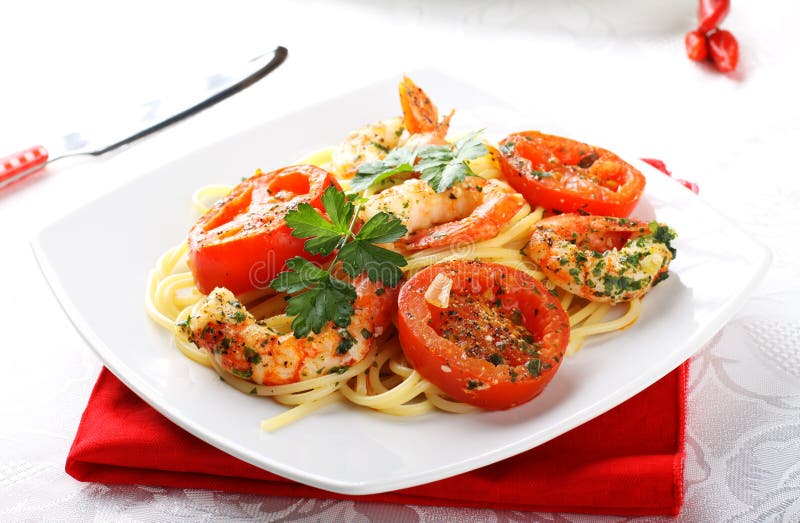 Pasta with shrimp, fresh tomatoes and parsley royalty free stock images