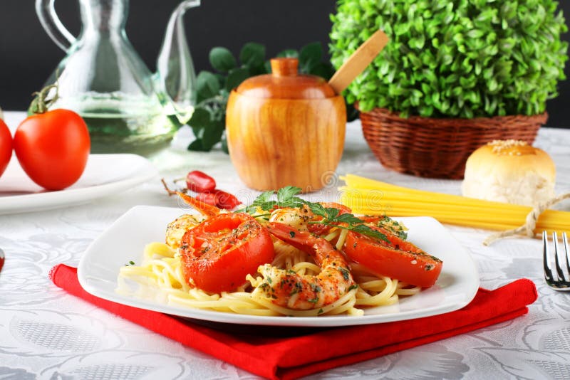 Pasta with shrimp, fresh tomatoes and parsley stock images