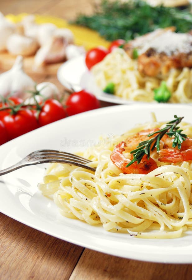 Pasta with shrimps and sauce on the wooden table royalty free stock photography