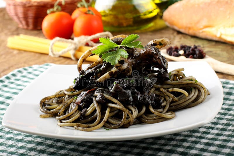 Pasta with squid ink and fresh tomatoes royalty free stock image