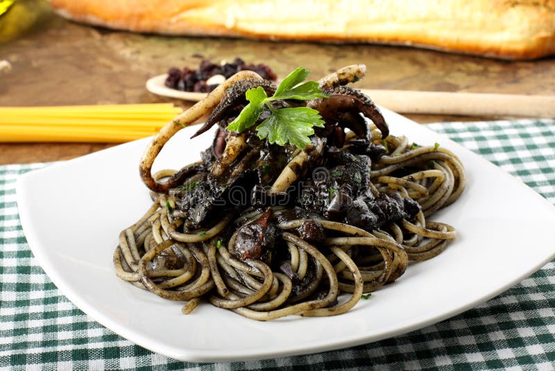 Pasta with squid ink and fresh tomatoes stock image