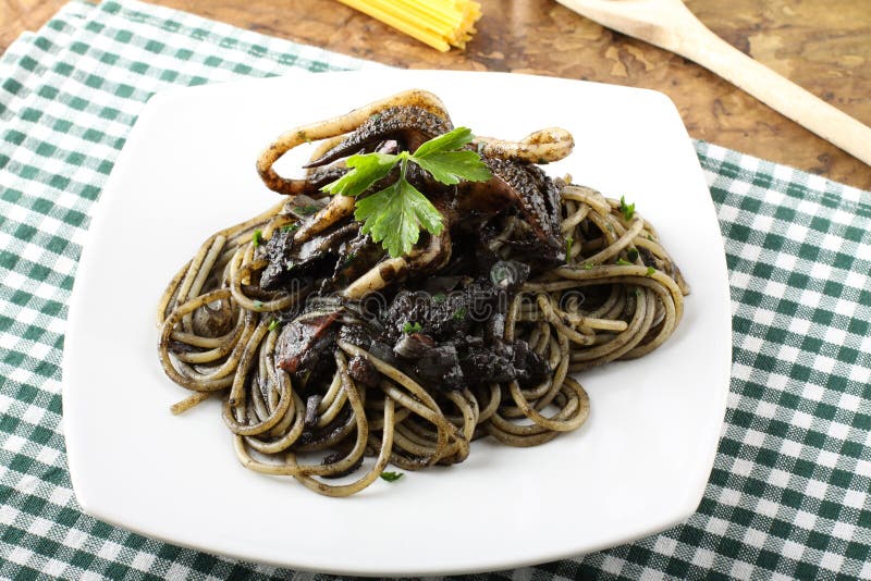 Pasta with squid ink and fresh tomatoes royalty free stock photos