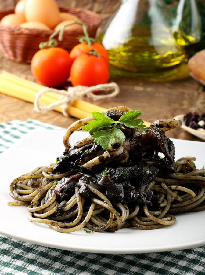 Pasta with squid ink and fresh tomatoes royalty free stock photos