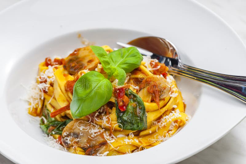 Pasta Tagliatelle with Tomato Sauce,champignon and Basil Leaves Stock