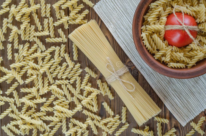 Pasta, tomater på träbakgrund och handduk - tappningeffekt royaltyfri bild Pasta, tomater på träbakgrund och handduk - tappningeffekt royaltyfri bild