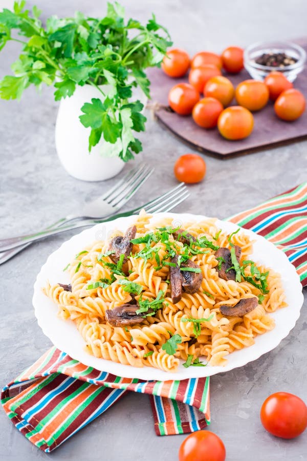 Pastas apetitosas con las setas fritas y las hierbas frescas en una placa imágenes de archivo libres de regalías Pastas apetitosas con las setas fritas y las hierbas frescas en una placa imágenes de archivo libres de regalías