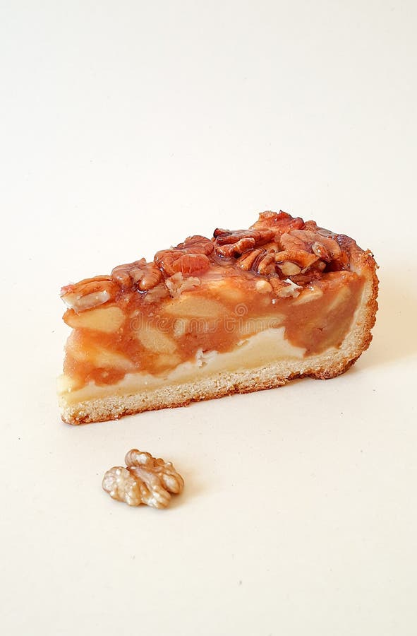 Pastas úteis Peça de maçã com pecans, caramelo e meia noz num fundo de luz comum imagens de stock Pastas úteis Peça de maçã com pecans, caramelo e meia noz num fundo de luz comum imagens de stock