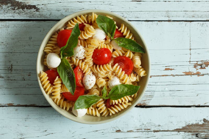 Pastasallad med körsbärsröda tomater och basilikasidor royaltyfri foto Pastasallad med körsbärsröda tomater och basilikasidor royaltyfri foto