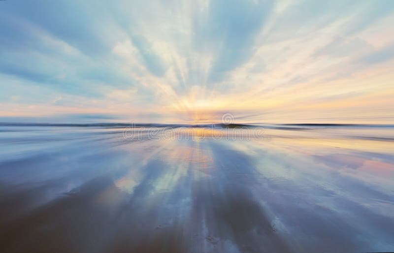 Pastel Color Sunset and Reflection on Sand with Slight Zoom Blur Stock
