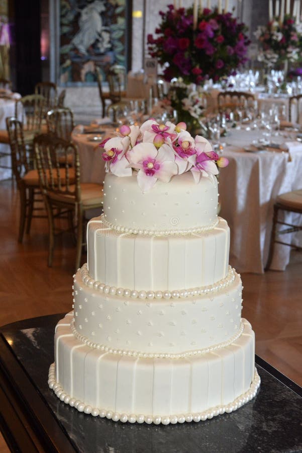 Pastel de bodas blanco de Glacé con las perlas y las flores rosadas, partido de cena fotografía de archivo Pastel de bodas blanco de Glacé con las perlas y las flores rosadas, partido de cena fotografía de archivo