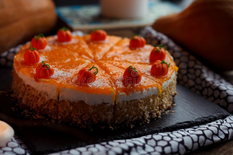 Pastel de calabaza hecho en casa sabroso anaranjado brillante redondo fresco americano tradicional en la tabla decorativa con el foto de archivo Pastel de calabaza hecho en casa sabroso anaranjado brillante redondo fresco americano tradicional en la tabla decorativa con el foto de archivo
