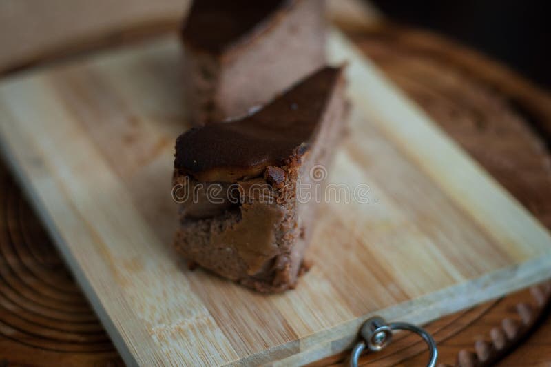 Pastel de queso quemado del chocolate en fondo de madera marrón imagen de archivo Pastel de queso quemado del chocolate en fondo de madera marrón imagen de archivo
