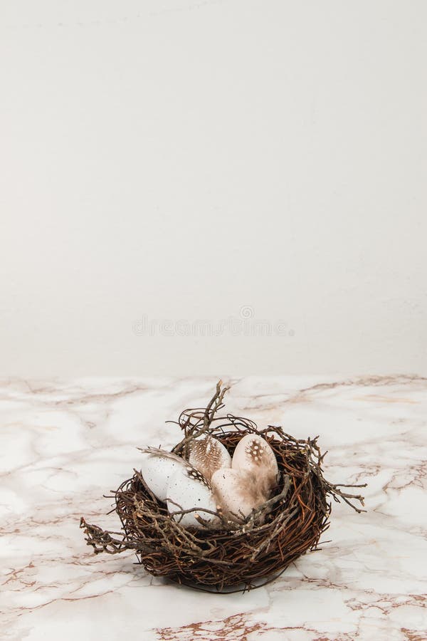 Pastel Easter Eggs in Bird`s Nest on a Marble Background Stock Photo