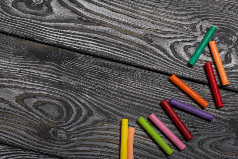 Pastel for drawing. Sticks of different colors. They lie on pine boards painted with white and black paint