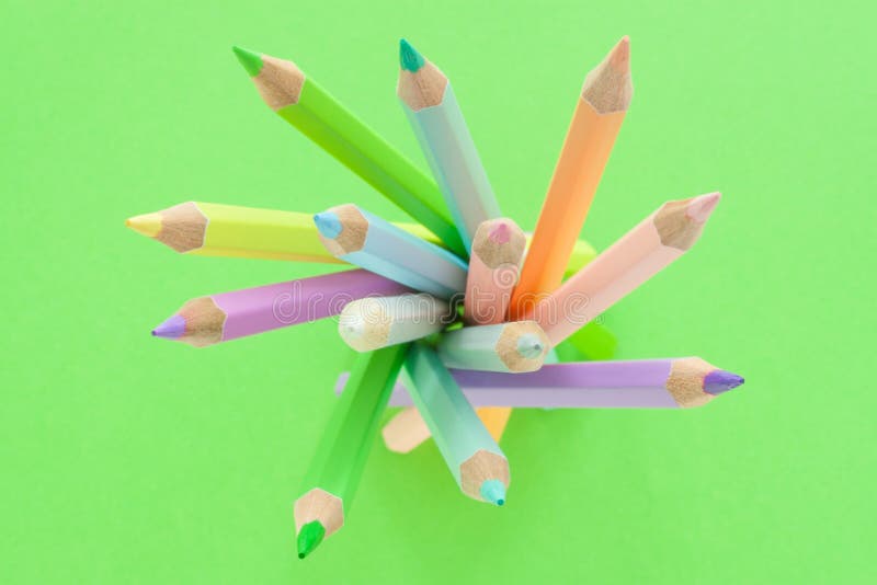 Pastel Multicolored Pencils on Empty Green Sheet of Paper Stock Image