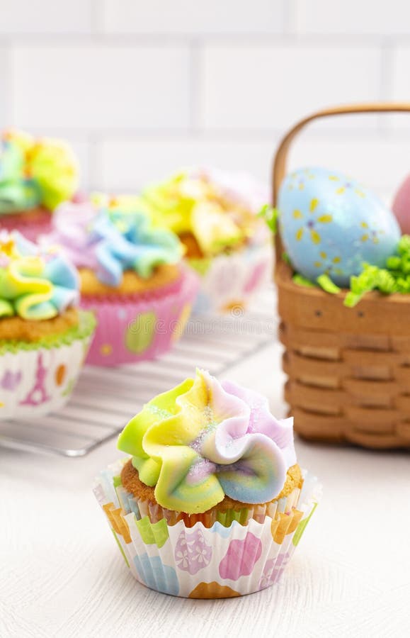 Pastel Rainbow Frosted Easter Cupcakes on a Kitchen Counter Stock Photo