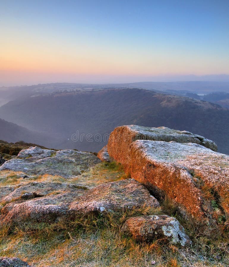 Beautiful pastel sunrise at Mel Tor Dartmoor South Devon England with frost lingering on the granite rocks of the tor. Beautiful pastel sunrise at Mel Tor Dartmoor South Devon England with frost lingering on the granite rocks of the tor