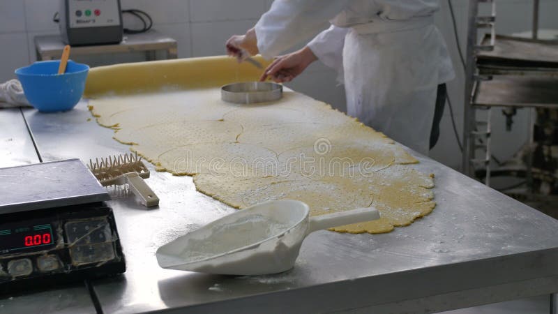 Pasteles que son cortados de la hoja en panadería industrial