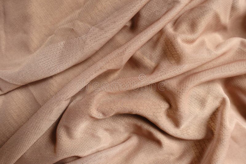 Pastellbeiges Polyester-Mesh-Gewebe in weichen Falten stockbild