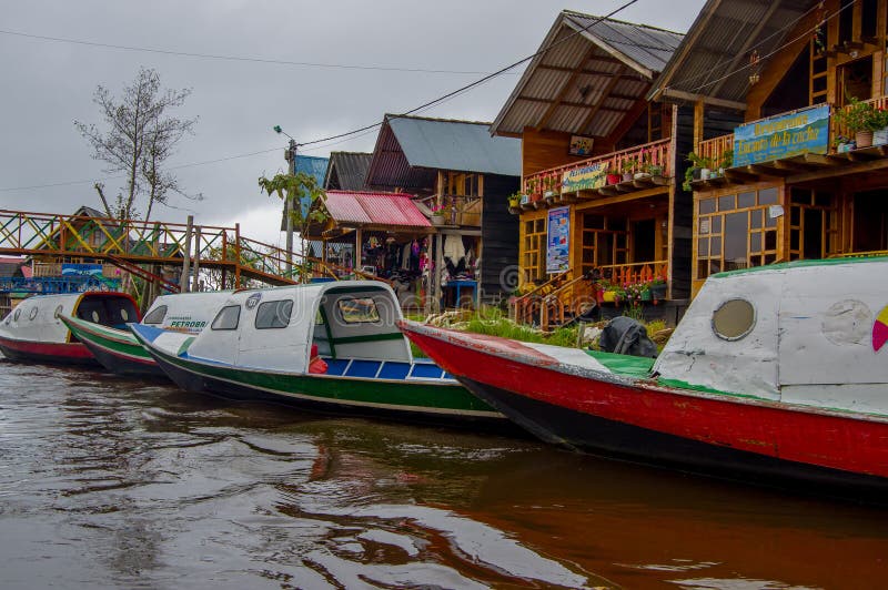 PASTO, COLOMBIA - JULY 3, 2016: colorfull boats parked in front of someshopes located on the shore of la cocha lake